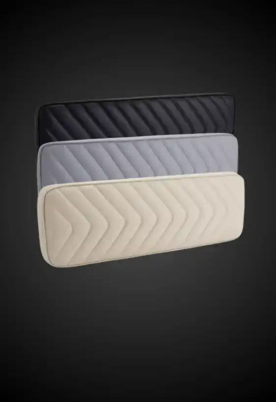 A stack of three rectangular, quilted headboards in black, gray, and beige.