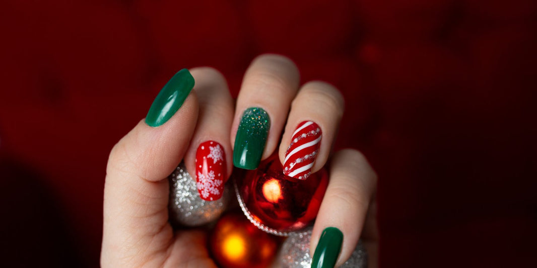 Christmas manicure with a red and white candy cane stripe accent nail, green nails and a red snowflake nail