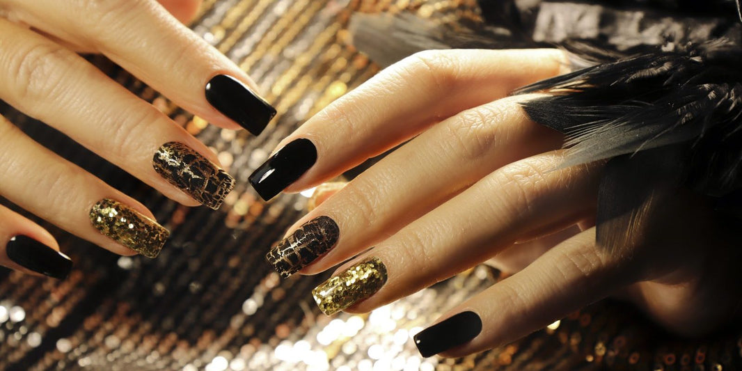 Long square nails in glossy black with gold sequin and black crackle accent nails on a gold sequin background
