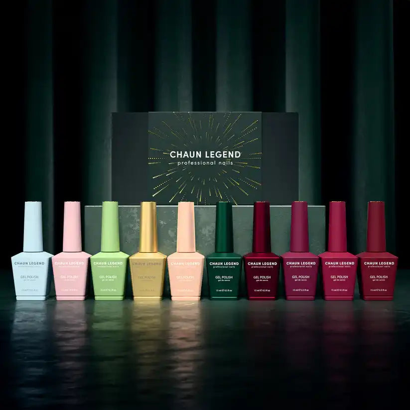 Collection of nail polish bottles in various pastel and jewel-toned colors arranged in a gradient line.