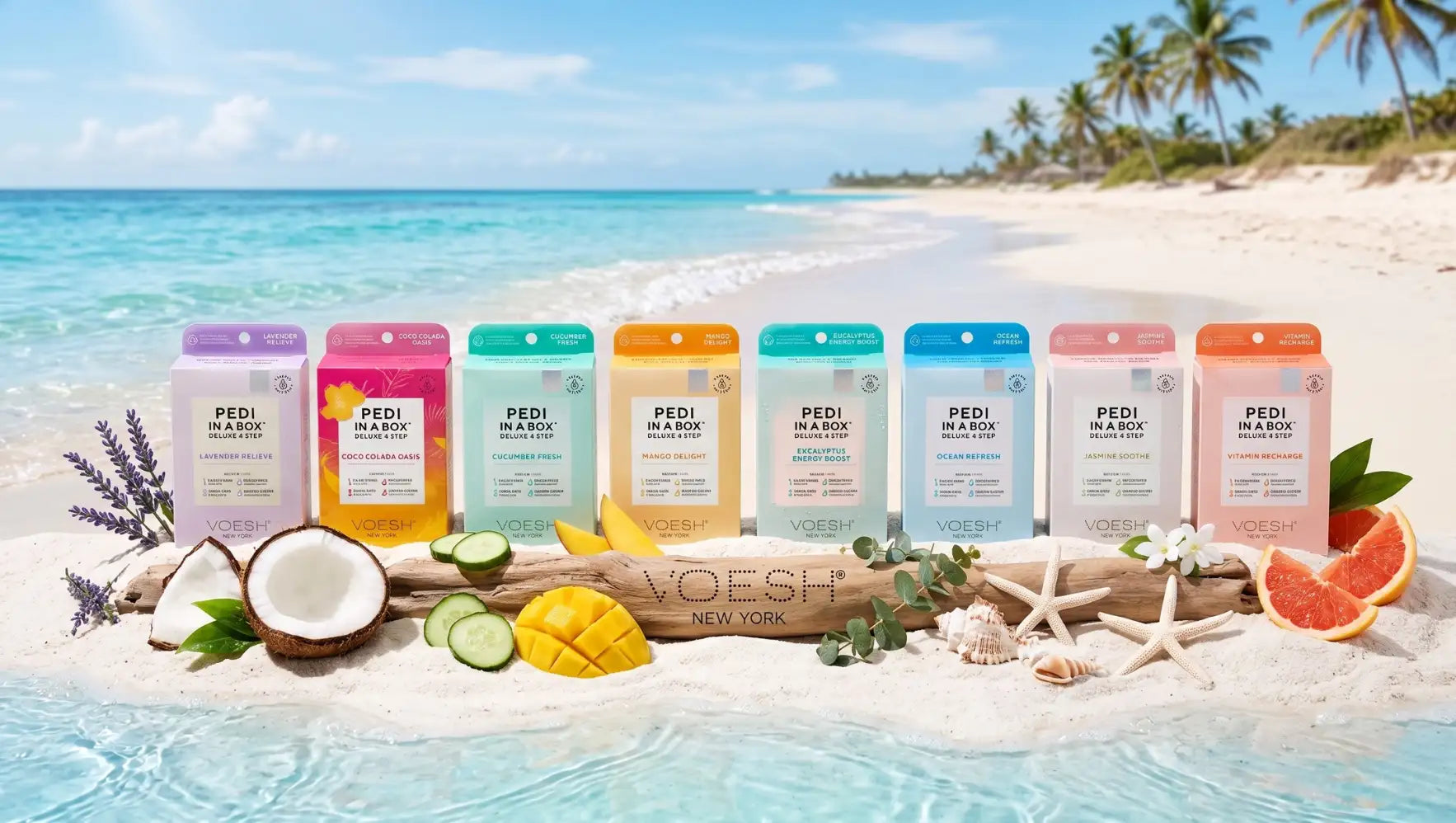 A row of colorful, rectangular pedi in a box foot soak packets arranged on sandy beach with tropical fruit and coconut halves.
