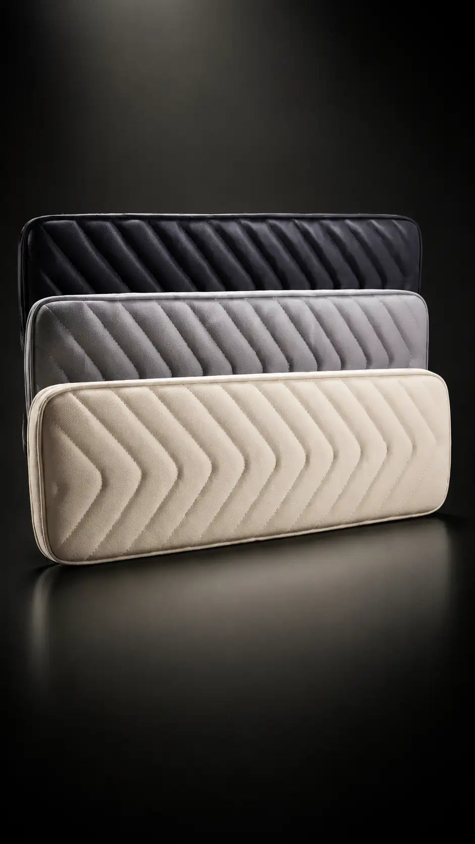 Three quilted laptop sleeves in black, gray, and beige with a chevron pattern.